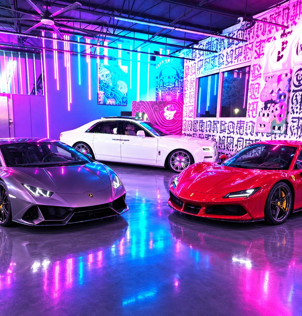 A white Rolls-Royce Ghost under neon light in the AutoVault facility